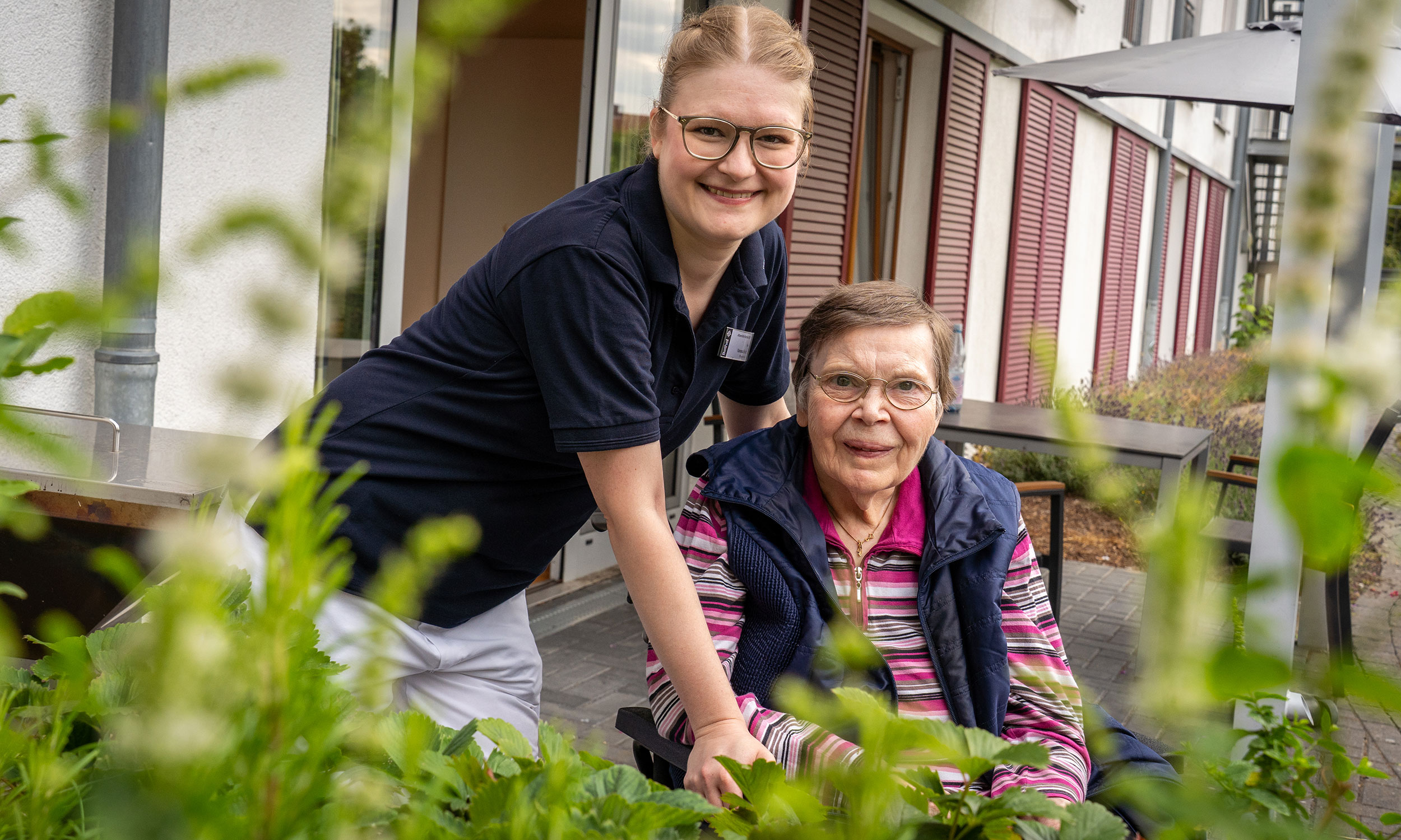 Pflegekraft mit Bewohner im Garten der Pflegeeinrichtung Haus Elim | Elim MeH Bethel in Bielefeld
